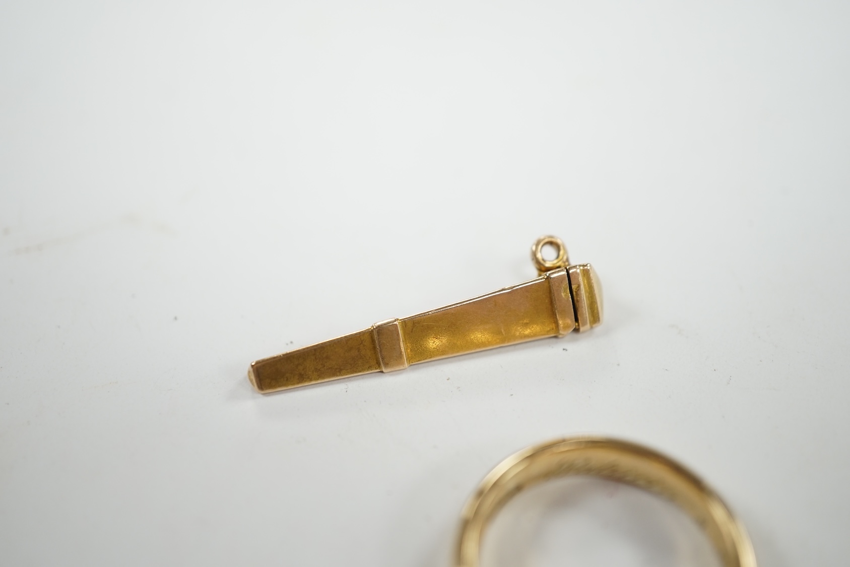 A 9ct gold wedding band, with engraved inscription, size Q and a yellow metal needle? case, 8.4 grams. Condition - fair